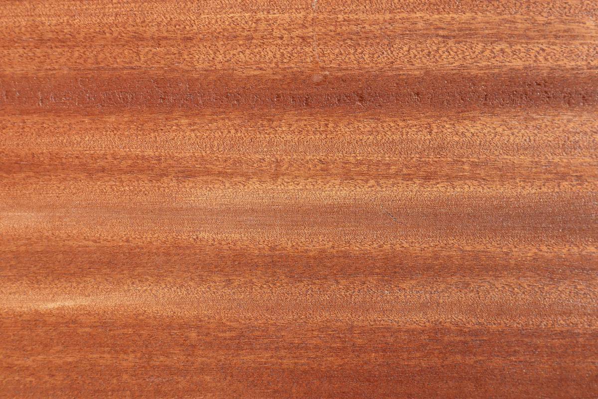 Hand applying diy wood preservative mixtures to rough-sawn cedar plank with brush